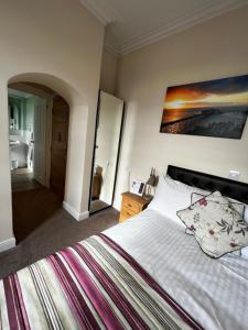 a bedroom with a large bed and a bathroom at Queenswood Hotel in Weston-super-Mare