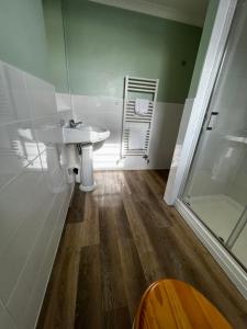 a bathroom with a sink and a glass shower at Queenswood Hotel in Weston-super-Mare