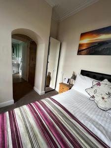 a bedroom with a large bed with a painting on the wall at Queenswood Hotel in Weston-super-Mare