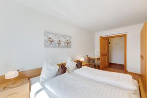 a bedroom with a white bed and a desk at Moar im Rumsein - Apt Etschblick in San Genesio Atesino