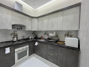a kitchen with gray cabinets and a white appliance at Samarkand luxury apartment #5 in Samarkand