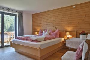 1 Schlafzimmer mit 2 Betten und einer Holzwand in der Unterkunft Landhaus Barbara in Kitzbühel