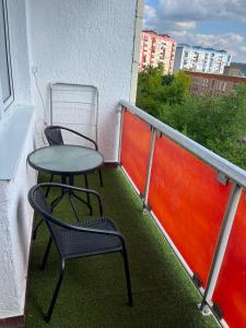 a balcony with two chairs and a table on it at Horizont-Szilvás Apartman in Komló
