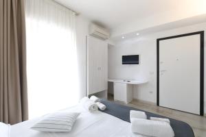 una camera da letto con un grande letto bianco e uno specchio di L' Arcobaleno Resort a Capo Vaticano