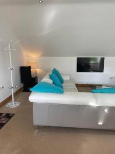 - un lit blanc avec des oreillers bleus dans l'établissement Luxury Studio Loft with Car Charging Point, à Frizington