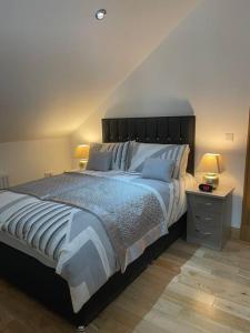a bedroom with a large bed with blue sheets and pillows at Luxury Studio Loft with Car Charging Point in Frizington