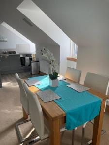 a dining room table with chairs and a blue table cloth at Luxury Studio Loft with Car Charging Point in Frizington