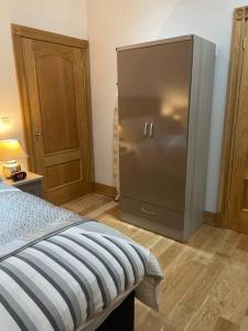 ein Schlafzimmer mit einem Metallkühlschrank in einem Zimmer in der Unterkunft Luxury Studio Loft with Car Charging Point in Frizington