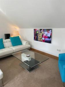 a living room with a white couch and a glass table at Luxury Studio Loft with Car Charging Point in Frizington
