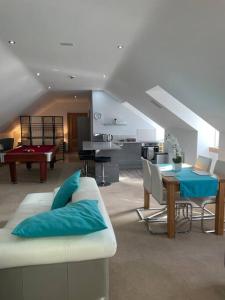 a living room with a couch and a dining room with a pool table at Luxury Studio Loft with Car Charging Point in Frizington
