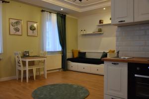 ein Wohnzimmer mit einem Sofa und einem Tisch sowie eine Küche in der Unterkunft Apartamenty Coco Premium Saska Kępa in Warschau