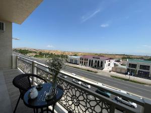 a table on a balcony with a view of a street at Samarkand luxury apartment #5 in Samarkand