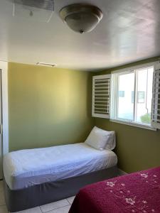 a small bedroom with a bed and a window at Spacious Private Los Angeles Bedroom with AC & WIFI & Private Fridge near USC the Coliseum Exposition Park BMO Stadium University of Southern California in Los Angeles