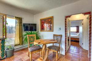 comedor con mesa de madera y sillas en Adobe Escape with Hot Tub and Art for Sale!, en El Prado