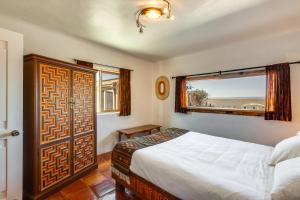 Un dormitorio con una cama grande y una ventana en Adobe Escape with Hot Tub and Art for Sale!, en El Prado