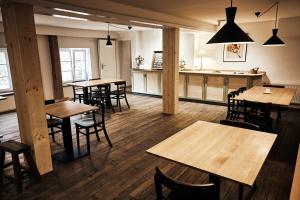 a restaurant with wooden tables and chairs and a bar at Alte Mühle Maising in Pöcking