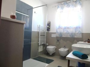 een badkamer met een douche, een toilet en een wastafel bij Casa Vacanza LiHele - Locazione Turistica in Castelsardo
