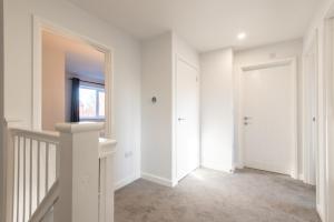 a white hallway with a door and a window at No 205 in Doncaster
