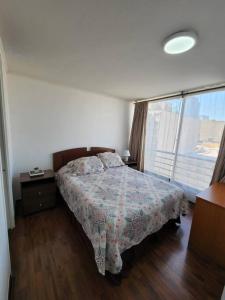 a bedroom with a bed and a large window at Familiar en el centro de Santiago 16 B in Santiago