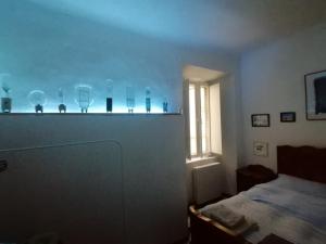 a room with glass on a police with a bed w obiekcie Gallery House w mieście Fermo
