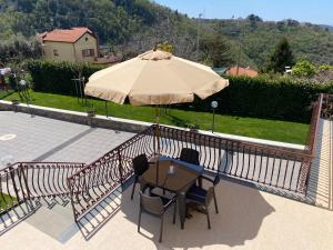 un patio con mesa y sombrilla en Villa Cinque, en Vico Equense