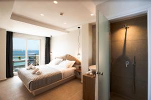 a bedroom with a bed and a bathroom with a shower at Magic View Suites Mykonos in Mikonos