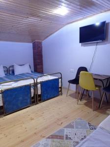 Pokój z dwoma łóżkami, stołem i telewizorem w obiekcie Gallery w mieście Tsʼageri