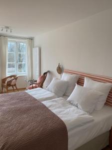 a large bed with white pillows in a bedroom at Alte Mühle Maising in Pöcking