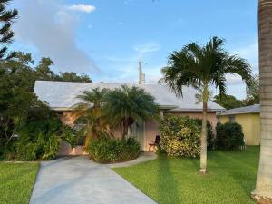 a house with palm trees and a driveway at Vintage Vero Bungalo II in Vero Beach