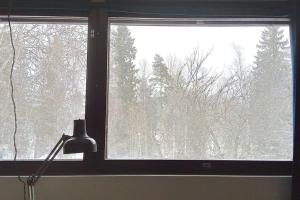 a window with a view of a snow covered forest at 21 minutes from Helsinki city - smaller room in Kauniainen