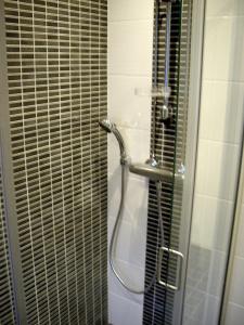 a bathroom with a shower with a glass door at 21 minutes from Helsinki city - smaller room in Kauniainen