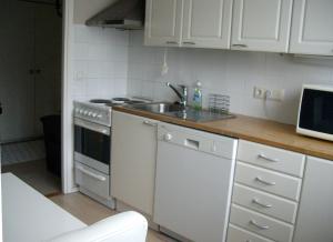 a kitchen with a sink and a stove at 21 minutes from Helsinki city - smaller room in Kauniainen