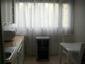eine Küche mit einem Fenster und weißen Vorhängen in der Unterkunft 21 minutes from Helsinki city - smaller room in Kauniainen