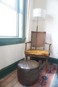 einen Stuhl und eine Ottomane in einem Zimmer in der Unterkunft Charming Victorian Home In Historic District in Newburgh
