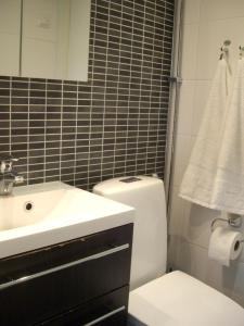 ein Badezimmer mit einem Waschbecken, einem WC und einem Spiegel in der Unterkunft 21 minutes from Helsinki city - smaller room in Kauniainen