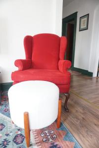 a red chair and a stool in a living room at Charming Victorian Home In Historic District in Newburgh