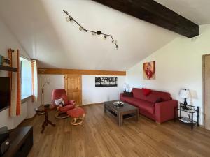 ein Wohnzimmer mit einem roten Sofa und einem Tisch in der Unterkunft Ferienwohnung Gruberhof in Rimsting