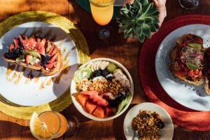 a table topped with plates of food and bowls of fruit at Hotel Boutique Punta Caliza - Adults Oriented in Holbox Island