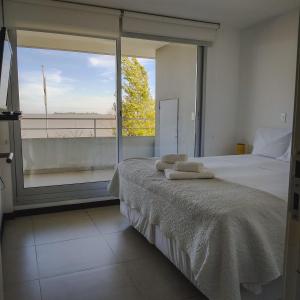 1 dormitorio con cama y ventana grande en Dos Orillas - Apartamento 302, en Colonia del Sacramento