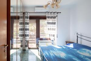 um quarto com uma cama azul e uma janela em EUR Mostacciano - 6 ospiti WIFi AC em Roma