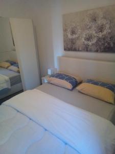 a bedroom with two beds and a painting on the wall at Apartments Lili in Zadar
