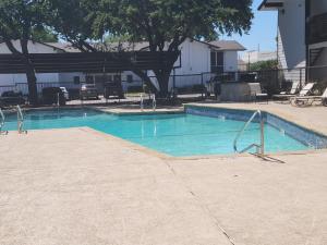 a swimming pool with blue water in a yard at Five Minutes from At&t Stadium, Globe Life & More in Arlington