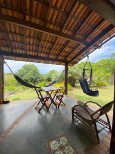 a porch with a hammock and a table and chairs at Casa nos Algodoes in Marau