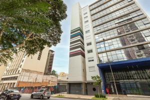 um edifício branco alto numa rua da cidade em BVV - Bem Viver By Anora Spaces em São Paulo