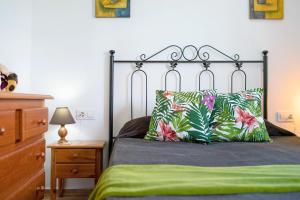 um quarto com uma cama com um cobertor verde e almofadas em Casa Manoli 3 Chiclana em Chiclana de la Frontera