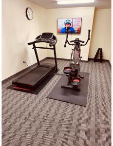 une chambre avec un vélo d'appartement et un tapis de course dans l'établissement Aurora Park Inn & Suites, à Dawson Creek