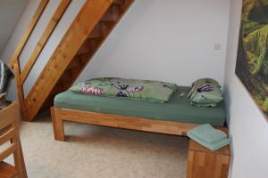 Una cama pequeña en una habitación junto a una escalera. en Bauernhof-Gästezimmer Waldblick en Buchenbach