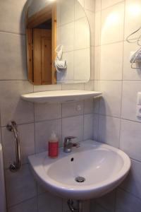 a bathroom with a white sink and a mirror at Bauernhof-Gästezimmer Waldblick in Buchenbach