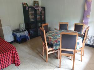Zion Care Homestay في أروشا: طاولة وكراسي في غرفة مع طاولة