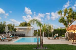 a villa with a swimming pool and palm trees at Villa Tranquilla in Kolymvari